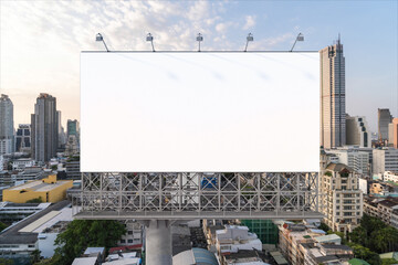 Blank white road billboard with Bangkok cityscape background at sunset. Street advertising poster, mock up, 3D rendering. Front view. The concept of marketing communication to promote or sell idea.