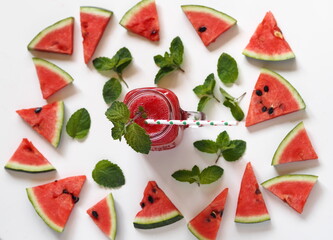 Watermelon smoothie or juice with pulp in a glass with a handle on a white plate with watermelon slices. Healthy wholesome natural food.