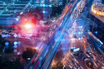 Obraz premium World planet Earth map hologram on aerial view of road, busy urban traffic highway at night. Junction network of transportation infrastructure. The concept of success in logistics business.