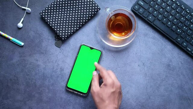 top view of man hand using smart phone on office desk 