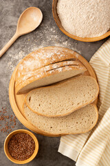 Whole grain round bread on dark background. Bread for breakfast.