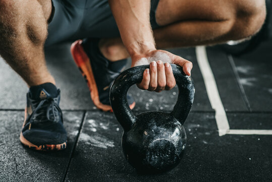 Muscular Man Holding A Weight Above The Fitness Floor