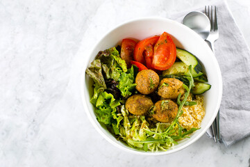 Falafel and fresh vegetables mixed salad on white background, top view. Vegetarian, food concept.