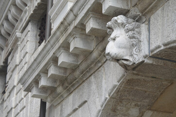 
architectural detail of the facade of a building with a sculpture depicting the head of a lion