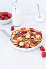Mini pancakes with strawberries on a light background. Tasty breakfast. Food trending. Baby food