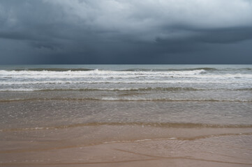 Storm clouds over the sea.The waves hit to the beach before rainy on seascape background.Bad...