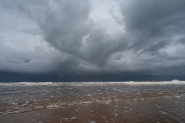 Storm clouds over the sea.The waves hit to the beach before rainy on seascape background.Bad weather for outdoor travel.