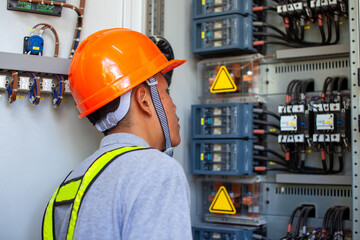 Electrician inspect in front of fuse switch board system.