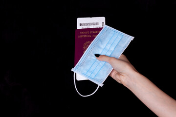 hand holding italian passport and surgery mask - travel in the age of coronavirus
