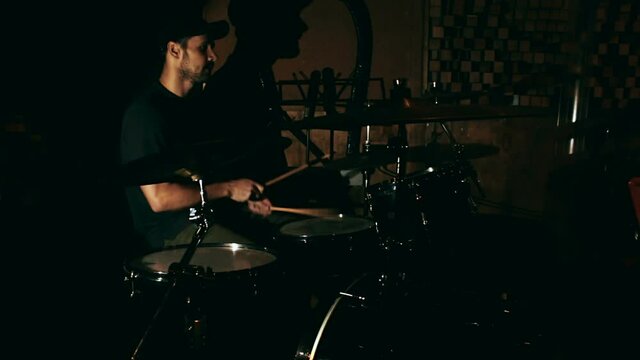 Close-up shot of a drummer playing a drum kit. Young handsome guy plays drums at a rock concert.A young drummer is practicing his skills.