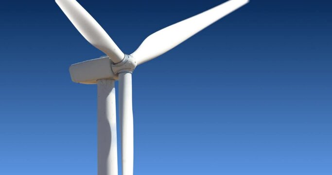 Close up, side view of a rotaing wind tower turbine electricity gererator, renewable energy source.