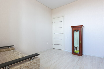The interior of a modest small bedroom with very poor furniture