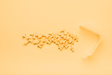 Yellow push pins on yellow background and box
