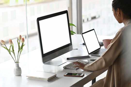 Two screen of computer with businesswoman typing her computer keyboard on modern office desk.