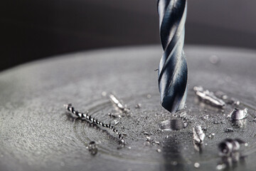 metal drill bit make holes in steel billet on industrial drilling machine. Metal work industry....