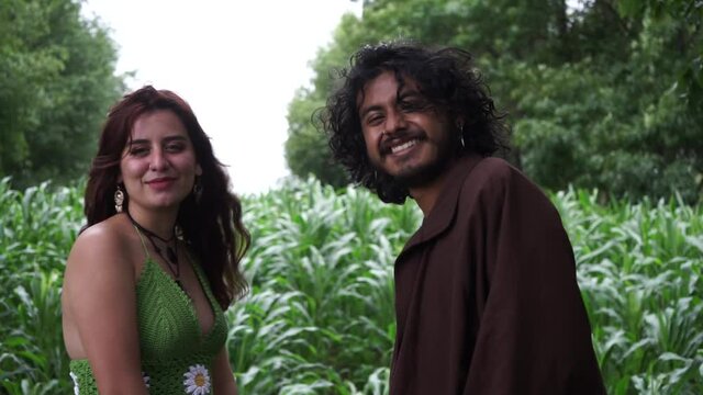 Couple smiling in the field. Caucasian hippie and afro american woman