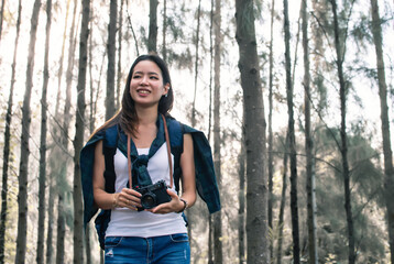 Asian woman traveling and camping in forest with happiness