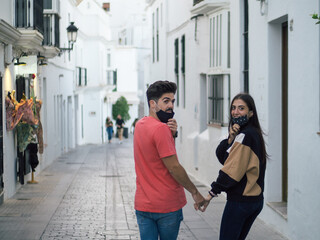 Pareja joven con mascarilla disfrutando de sus vacaciones respetando las medidas de seguridad de la...