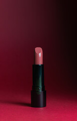 Lipstick on a dark red background. Cosmetics. Mock-up.