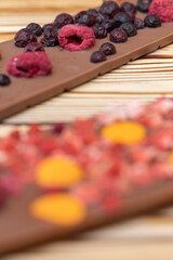 different kinds of chocolate with dried fruits on a wooden board