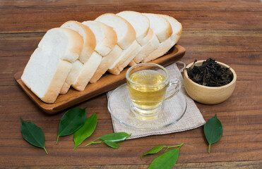 A cup of tea and bread on the wooden floor