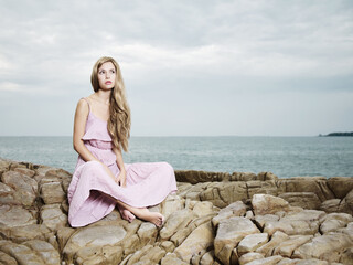 Fototapeta na wymiar Beautiful blonde woman on the beach. Lady in pink dress
