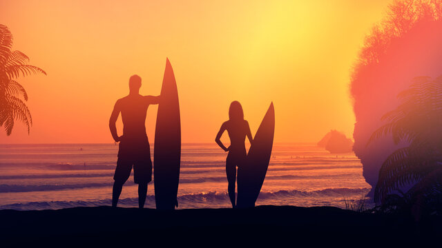 Silhouettes of surfers on a background of sunset in the ocean.