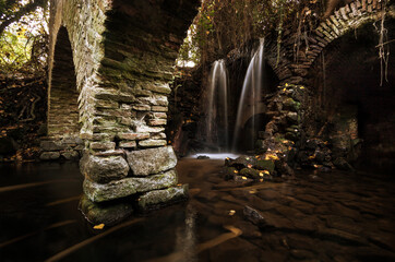 Waterfall in the ruins of an old mill. Nature scene, magical and relaxing