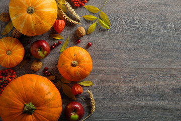 Thanksgiving background. Autumn composition with ripe pumpkins, autumnal fruits and dry leaves on...
