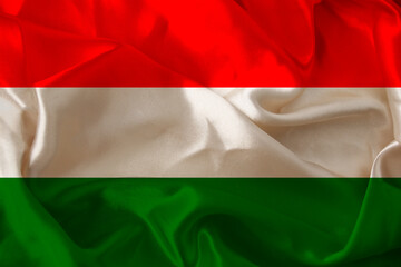 beautiful photo of the colored national flag of the modern European state of Hungary on textured fabric, concept of tourism, emigration, economics and politics, closeup