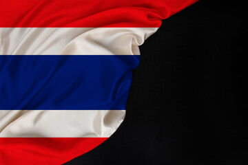 silk national flag of thailand state folded on black blank form, concept of tourism, economy, politics, emigration