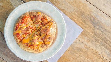 Tasty, flavorful pizza on plate with canvas napkin with lace on wooden table.
