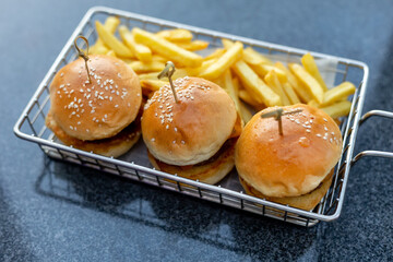 Mini burgers with french fries served at the bar, finger food