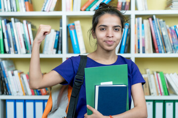 Cheering indian female student with books and paperwork