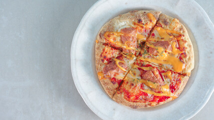Delicious pizza with sausages on wooden background, top view