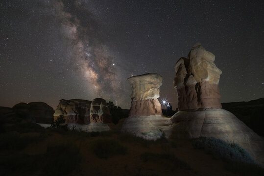 Night hiker standing on hoodoos in Devils Garden Utah 