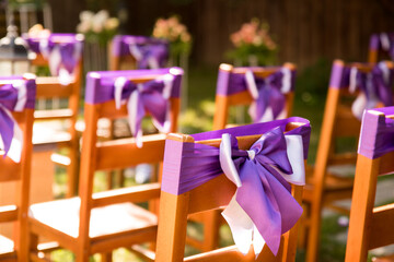 In the photo we see chairs decorated with lavender lilac ribbons. Outdoor wedding ceremony. Lavender-style location prepared.