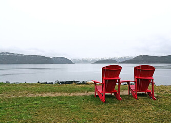 Red chairs in front of a lake in Gros Morne
