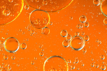 Water in oil in abstract style on yellow background. Orange liquid splash. Golden yellow bubble oil...