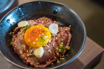 Gyudon, a Japanese dish consisting of a bowl of rice topped with rare beef with egg
