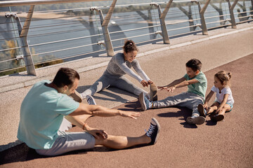 happy healthy and sporty family are doing workout trainings in sunny day