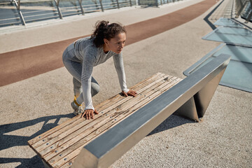 happy healthy and sporty woman is doing workout trainings in sunny day