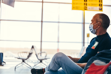 Airport attractive old man tourist boarding plane taking a flight  wearing face mask. Coronavirus flu virus travel concept banner panorama.