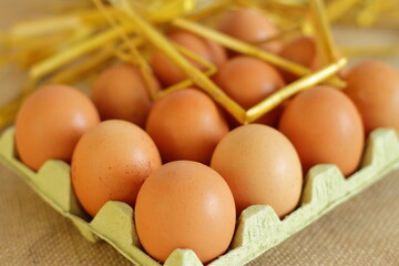 Tray of raw farm eggs on sackcloth background 