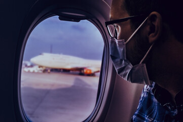 Airport European nerd man in glasses and plaid shirt with luggage tourist boarding plane taking a...