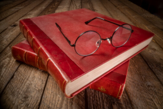 antique books and reading glasses - soft focus image shot with a lensless pinhole camera (camera obscura)