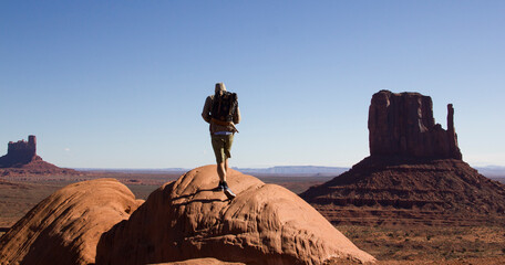 Uphill Monument Valley. Hiking Monument Mountain. Travel with backpack toward viewpoint.