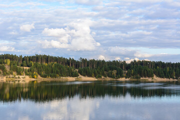 Emerald Lake with textural clouds, sandy mountains and forest. View from a high mountain.