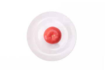 One single red ripe fresh raw tomato on white ceramic plate isolated on white, mediterranean diet concept