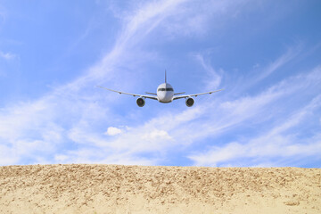 Airplane in the sky above the sand. Transport, travel